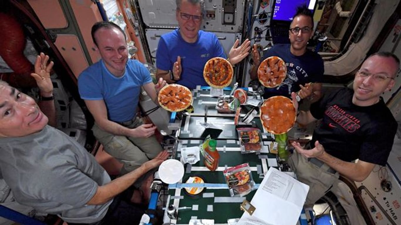 Astronauten auf der Internationalen Raumstation ISS zeigen ihre selbstgemachten Pizzen.