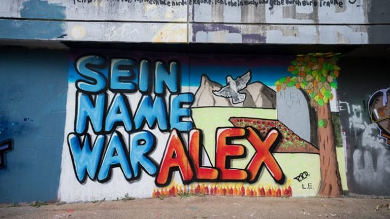 Auf einer Mauer ist ein Graffiti "Sein Name war Alex" für getöteten Tankstellen-Mitarbeiter gesprüht.