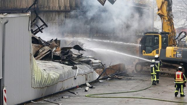 Mit einem Abrissbagger sucht die Feuerwehr nach letzten Brandnestern. Mit einem Abrissbagger sucht die Feuerwehr nach letzten Brandnestern.