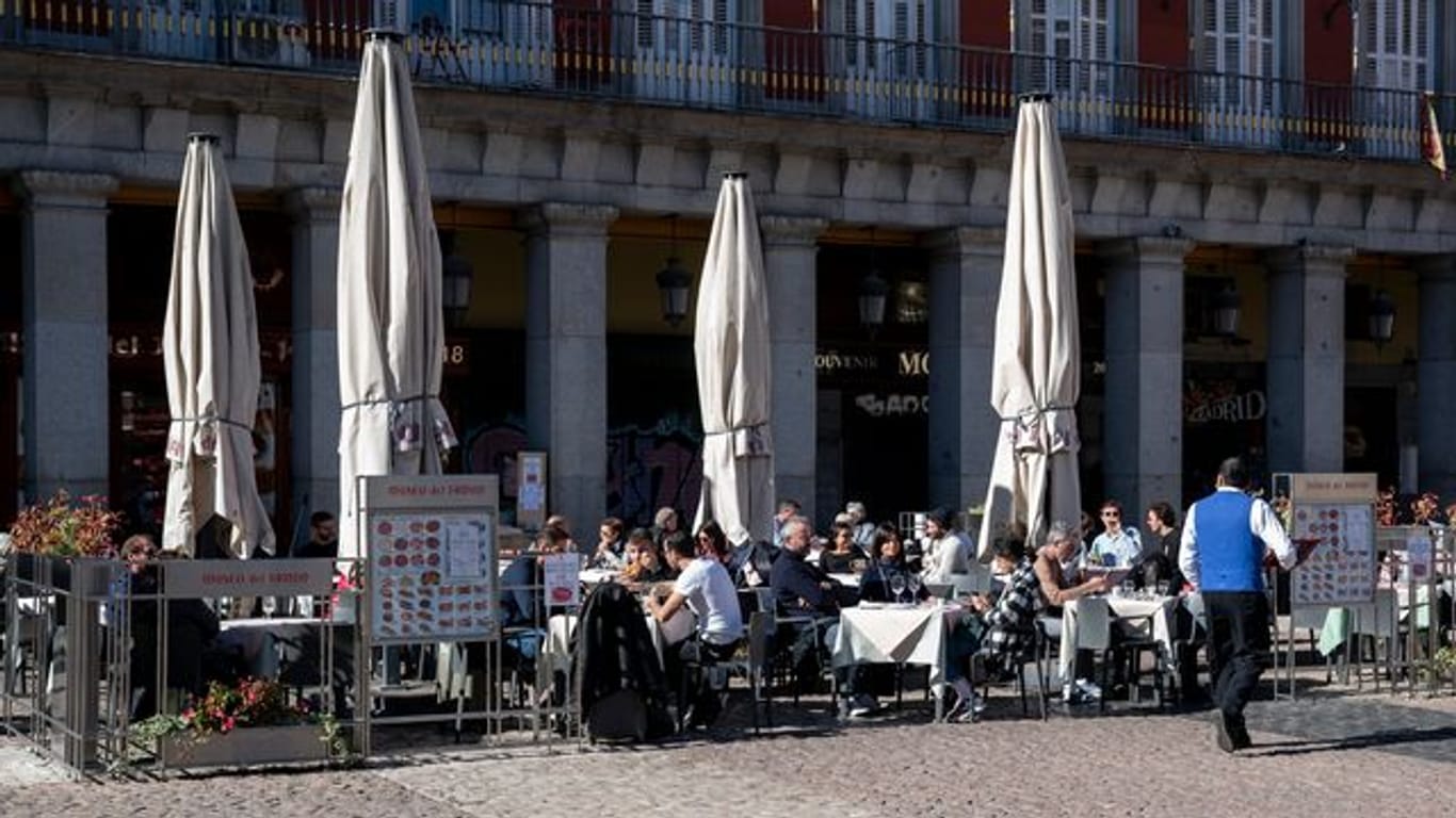 Kunden sitzen auf einer Terrasse in Madrid.