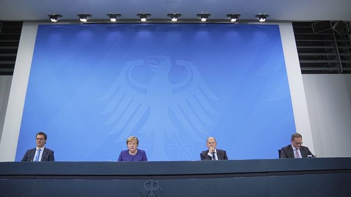 Hendrik Wüst, Angela Merkel, Olaf Scholz und Michael Müller nehmen an der Pressekonferenz im Bundeskanzleramt teil.