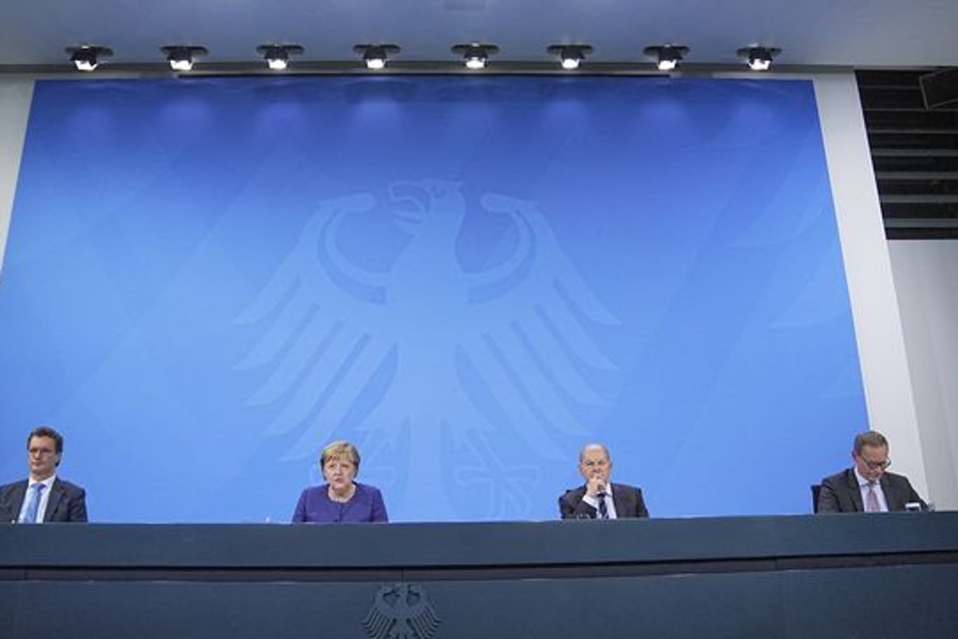 Hendrik Wüst, Angela Merkel, Olaf Scholz und Michael Müller nehmen an der Pressekonferenz im Bundeskanzleramt teil.