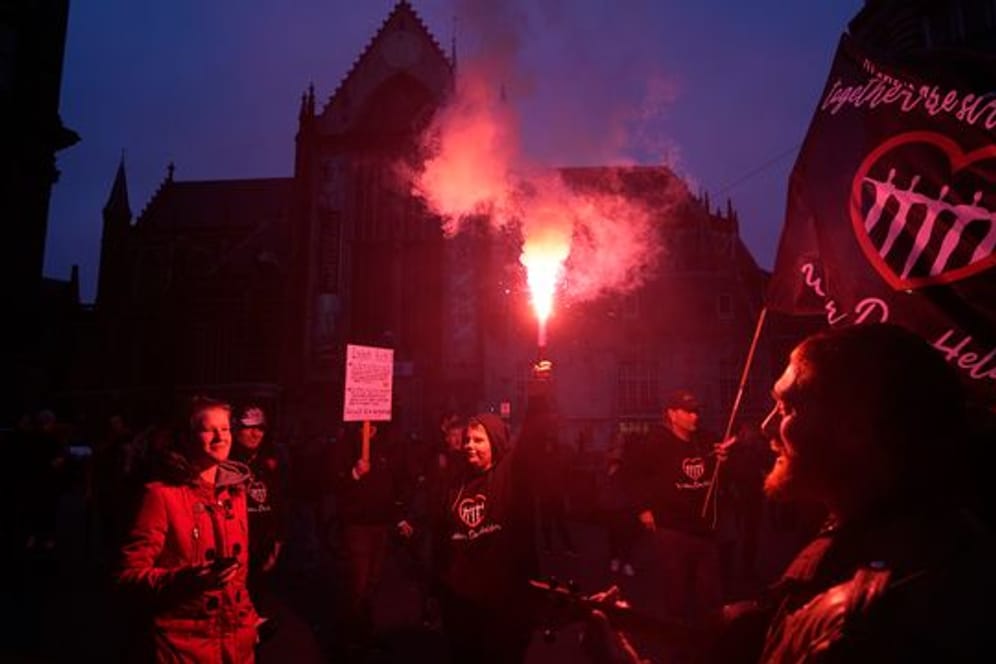 Menschen bei einer Demonstration gegen die Covid-19-Beschränkungen in Amsterdam teil.