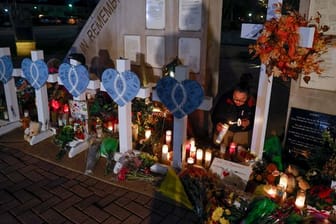 Eine Frau zündet Kerzen an einer Gedenkstätte im Veteran's Park für die Opfer an, nachdem ein Geländewagen am Sonntag in eine Weihnachtsparade gerast war, bei der mehrere Menschen getötet und Dutzende verletzt wurden.