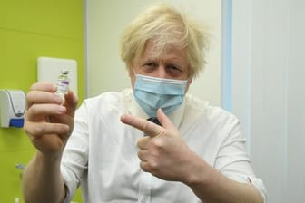 Boris Johnson, Premierminister von Großbritannien, hält ein Fläschchen mit Impfstoff von Astrazeneca während seines Besuchs in dem Corona-Impfzentrum des Zentrums für Gesundheit und Wohlbefinden in Orpington.