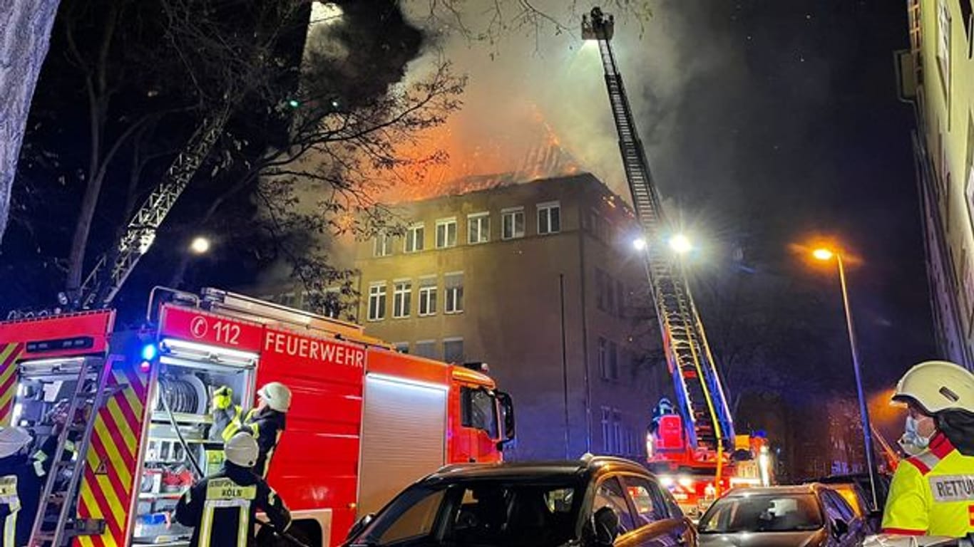 Einsatzkräfte der Feuerwehr löschen das brennende Schulgebäude.