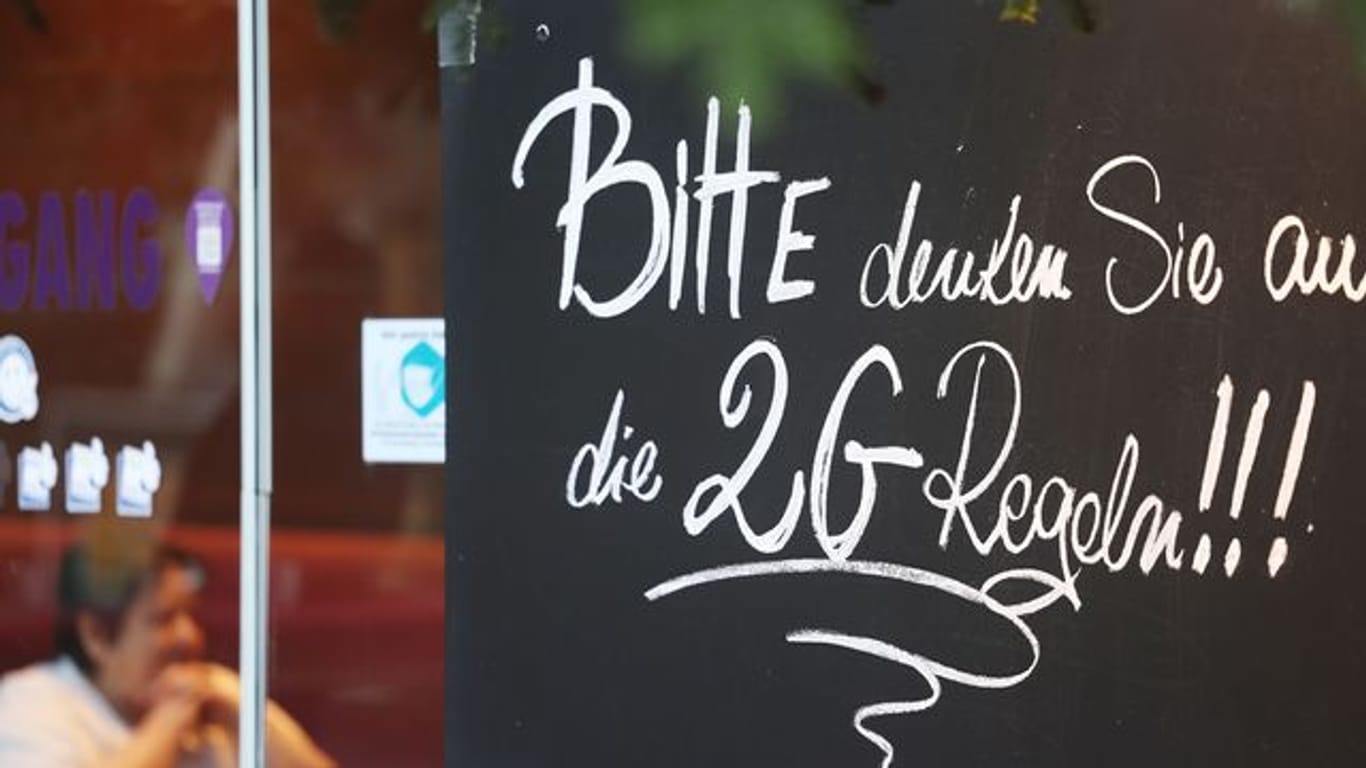 Ein Schild, das auf die 2G-Regeln hinweist, an einem Café in Bonn.