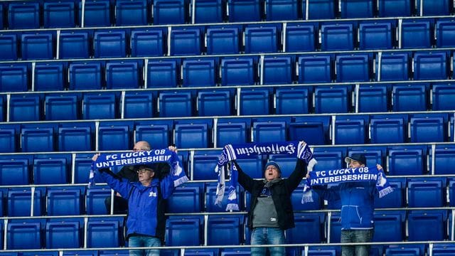 Die Zugangsregeln bei der TSG 1899 Hoffenheim werden weiter verschärft: Fans halten vor leeren Zuschauerrängen ihre Schals in die Höhe. Die Zugangsregeln bei der TSG 1899 Hoffenheim werden weiter verschärft: Fans halten vor leeren Zuschauerrängen ihre Schals in die Höhe.