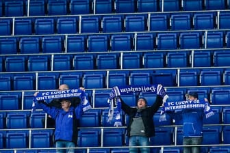 Die Zugangsregeln bei der TSG 1899 Hoffenheim werden weiter verschärft: Fans halten vor leeren Zuschauerrängen ihre Schals in die Höhe.