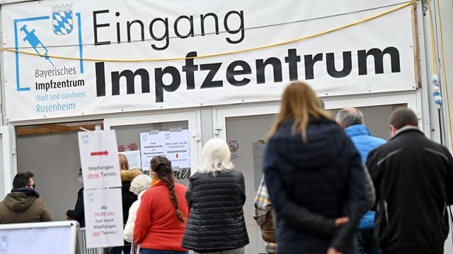 Impfwillige stehen vor dem Eingang des Impfzentrums in Rosenheim.