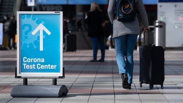 Ein Schild weist auf ein Corona-Testcenter am Flughafen München hin.