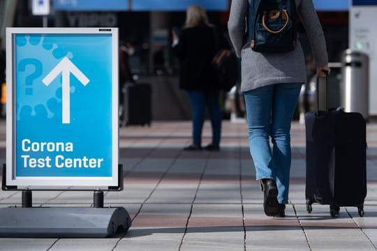 Ein Schild weist auf ein Corona-Testcenter am Flughafen München hin.