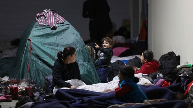 Das von der belarussischen Staatsagentur BelTA via AP zur Verfügung gestellte Handout zeigt Migranten, die sich in einem Logistikzentrum am Kontrollpunkt Kuznica nahe der belarussisch-polnischen Grenze ausruhen.