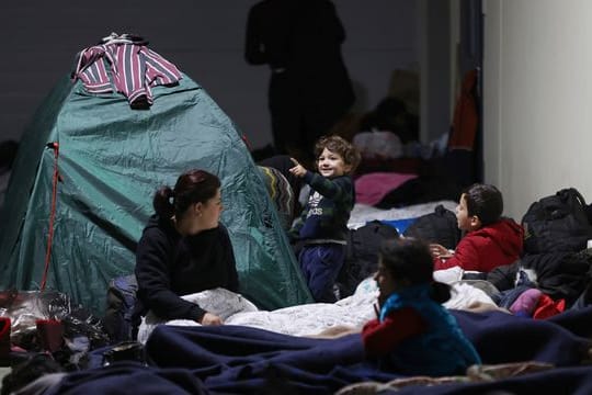 Das von der belarussischen Staatsagentur BelTA via AP zur Verfügung gestellte Handout zeigt Migranten, die sich in einem Logistikzentrum am Kontrollpunkt Kuznica nahe der belarussisch-polnischen Grenze ausruhen.