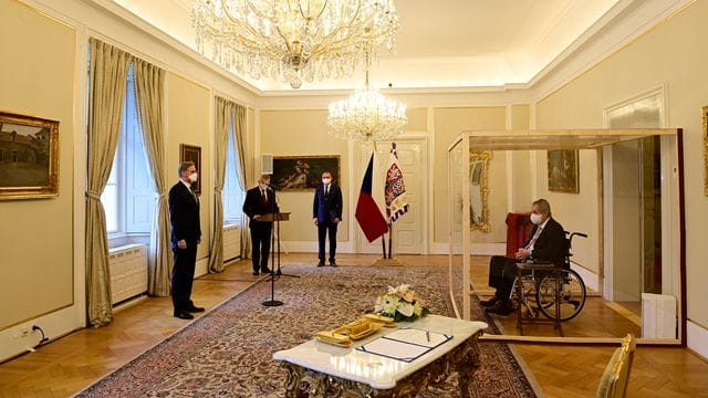 Der tschechische Präsident Milos Zeman (r) sitzt während der Vereidigung von Petr Fiala (l) in einem Rollstuhl hinter einer durchsichtigen Wand. Der tschechische Präsident Milos Zeman (r) sitzt während der Vereidigung von Petr Fiala (l) in einem Rollstuhl hinter einer durchsichtigen Wand.