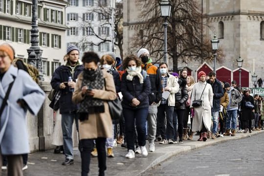 Wählerinnen und Wähler stehen für die Volksabstimmung über das 3G-Zertifikat in Zürich an.