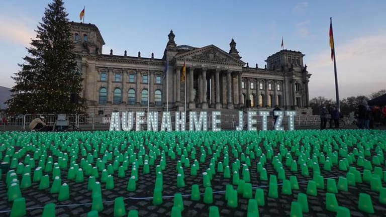 Ein Meer aus grünen Lichtern und der Schriftzug "Aufnahme Jetzt" vor dem Reichstag in Berlin.