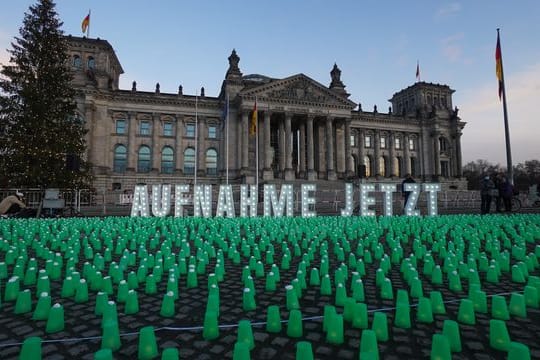 Ein Meer aus grünen Lichtern und der Schriftzug "Aufnahme Jetzt" vor dem Reichstag in Berlin.