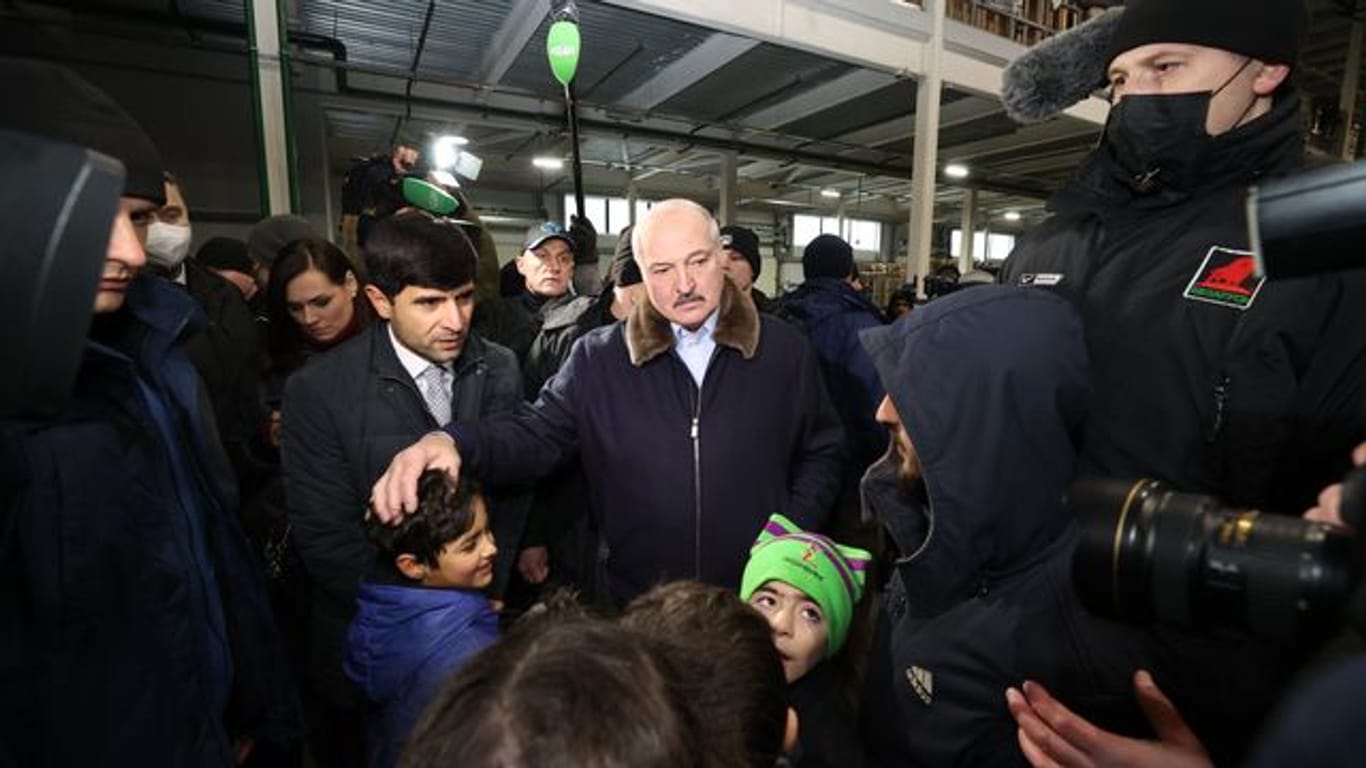 Der belarussische Machthaber Alexander Lukaschenko spricht mit Migranten in einem Logistikzentrum an der polnisch-belarussischen Grenze.