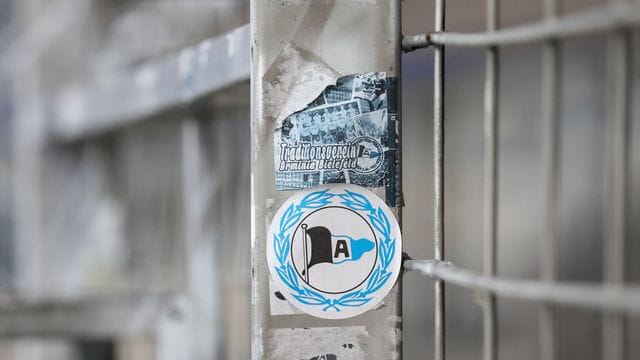 Ein Aufkleber mit dem Logo von Arminia Bielefeld klebt auf einem Zaun. Ein Aufkleber mit dem Logo von Arminia Bielefeld klebt auf einem Zaun.