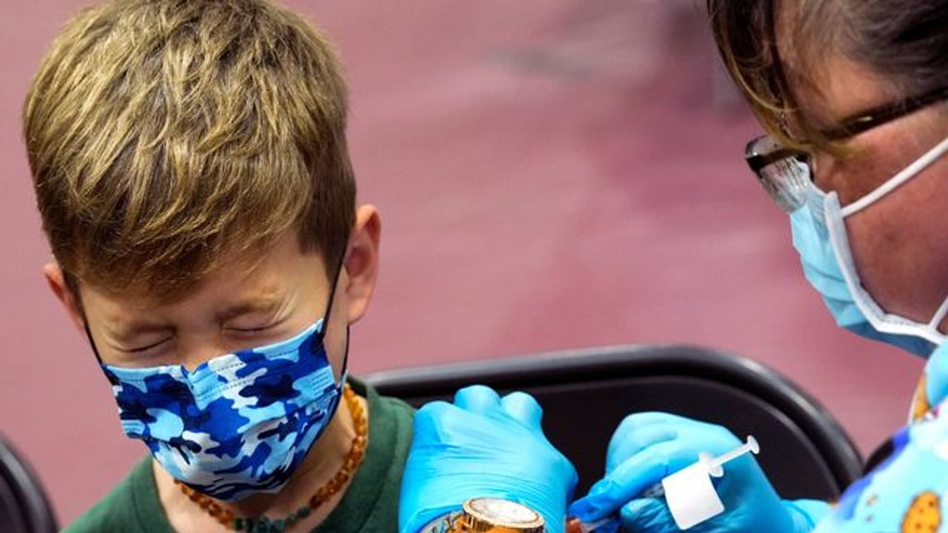 Ein Junge in den USA kneift während seiner Impfung die Augen zusammen.