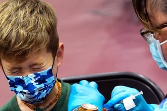 Ein Junge in den USA kneift während seiner Impfung die Augen zusammen.
