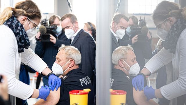Ein Polizeibeamter in Hannover lässt sich eine Auffrischungsimpfung gegen Covid-19 verabreichen. Ein Polizeibeamter in Hannover lässt sich eine Auffrischungsimpfung gegen Covid-19 verabreichen.