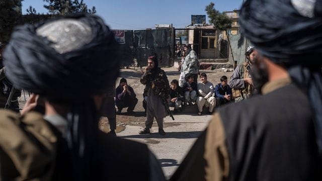 Taliban-Kämpfer in Kabul sichern nach der Explosion einer Bombe den Straßenrand.