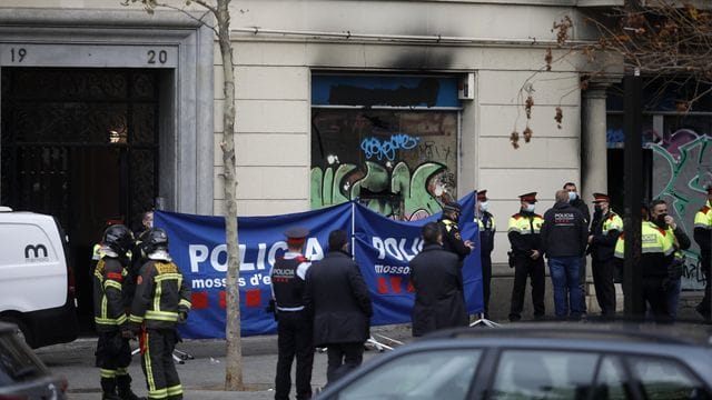 Polizeibeamte in der Nähe des Gebäudes in Barcelona, in dem ein Brand mit Todesopfern ausgebrochen ist. Polizeibeamte in der Nähe des Gebäudes in Barcelona, in dem ein Brand mit Todesopfern ausgebrochen ist.