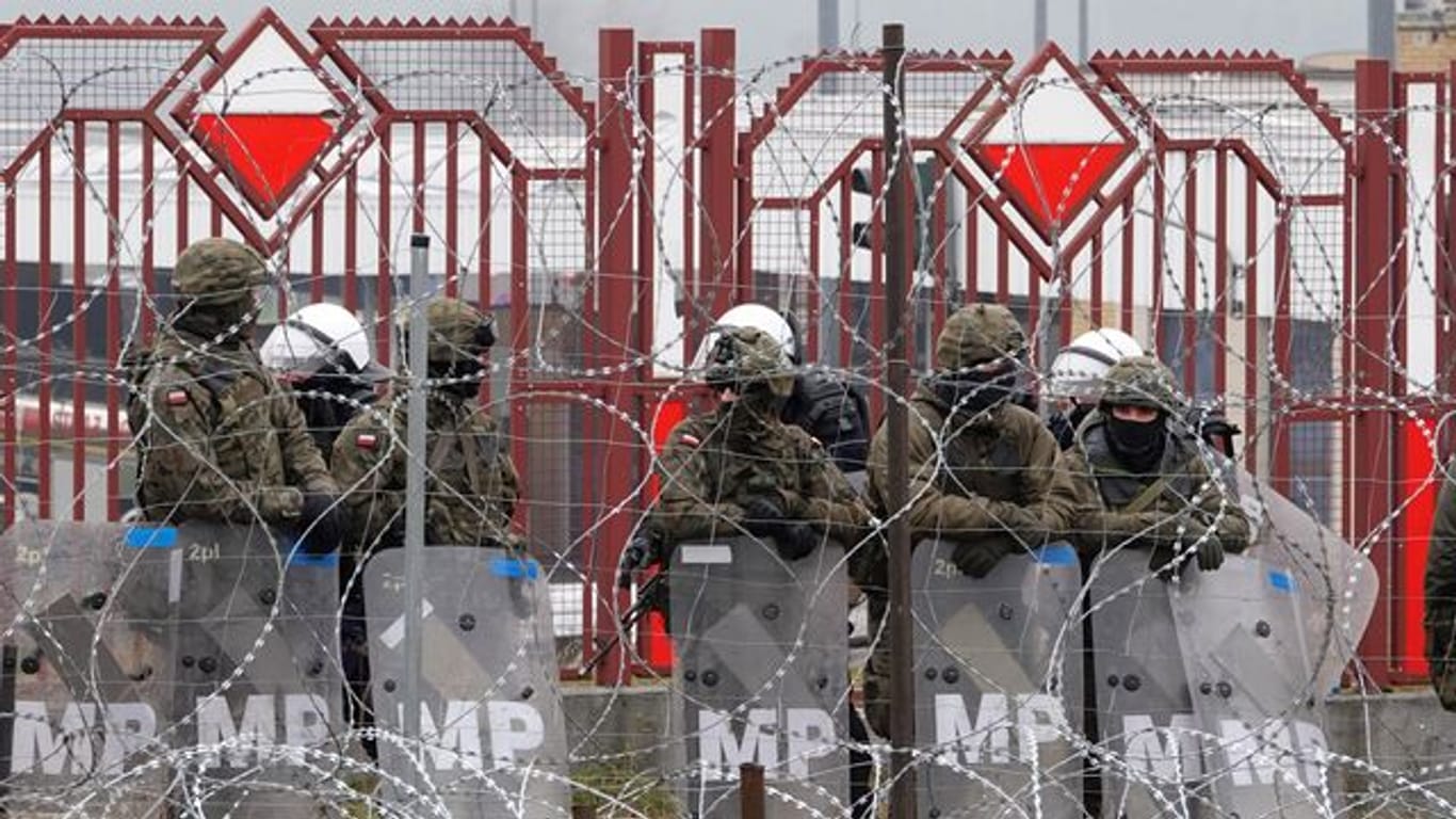 Polnische Sicherheitskräfte stehen hinter dem Grenzzaun am Grenzübergang Brusgi (Belarus) und Kuznica (Polen).