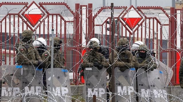 Polnische Sicherheitskräfte stehen hinter dem Grenzzaun am Grenzübergang Brusgi (Belarus) und Kuznica (Polen).