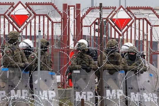 Polnische Sicherheitskräfte stehen hinter dem Grenzzaun am Grenzübergang Brusgi (Belarus) und Kuznica (Polen).