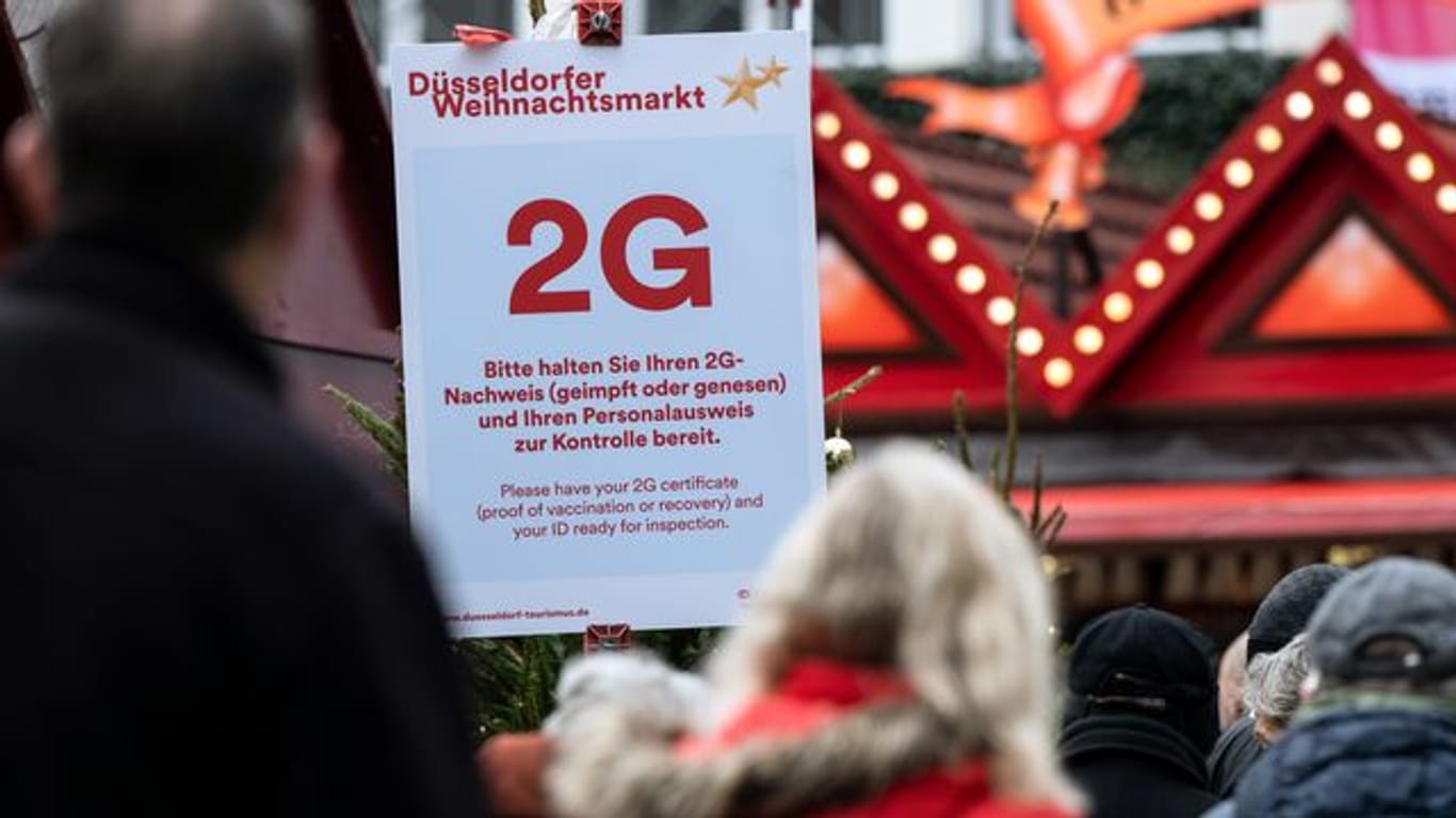 Ein 2G-Hinweisschild am Zugang des Düsseldorfer Weihnachtsmarkts. In der nordrhein-westfälischen Hauptstadt ist ein erster Fall der Omikron-Variante bestätigt worden.