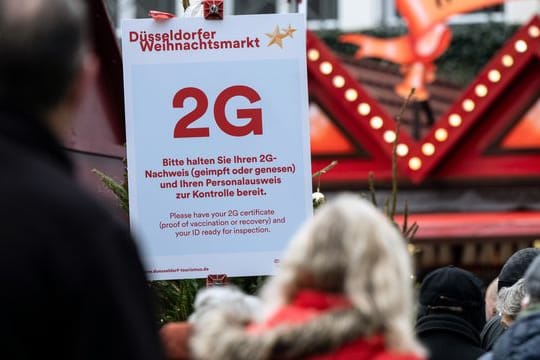Ein 2G-Hinweisschild am Zugang des Düsseldorfer Weihnachtsmarkts. In der nordrhein-westfälischen Hauptstadt ist ein erster Fall der Omikron-Variante bestätigt worden.