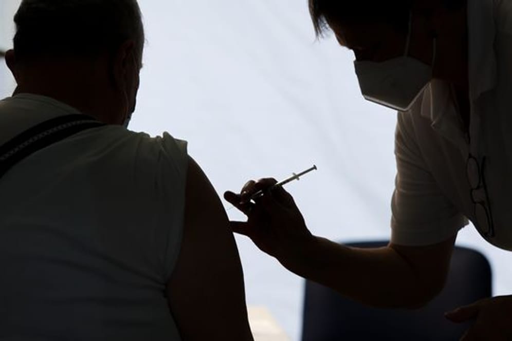 Eine Mitarbeiterin der Malteser impft einen Bürger in einem Impfzentrum in Sachsen-Anhalt.