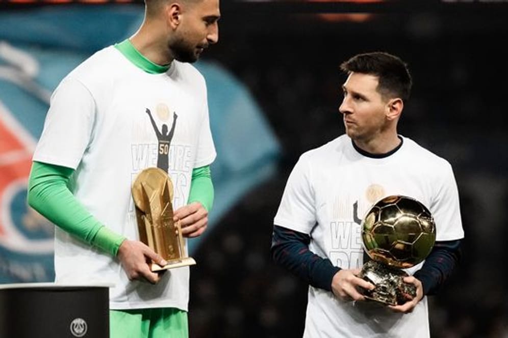 Vor dem Spiel gegen Nizza zeigen PSG-Torhüter Gianluigi Donnarumma (l) und Lionel Messi ihre Trophäe.
