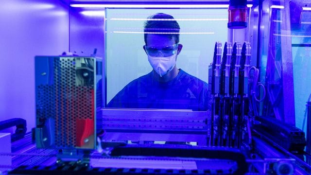 Ein Laborant untersucht in einem Labor an einem PCR-Vollautomaten Corona-Abstriche. Ein Laborant untersucht in einem Labor an einem PCR-Vollautomaten Corona-Abstriche.