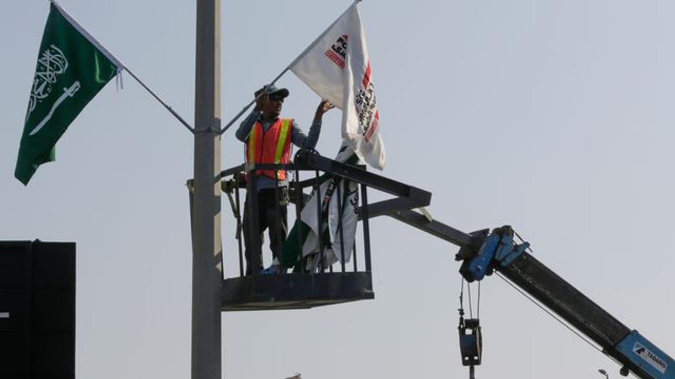 Ein Mitarbeiter hängt Flaggen an der Rennstrecke des Corniche Circuit auf: Die Formel 1 gastiert erstmals in Saudi-Arabien.