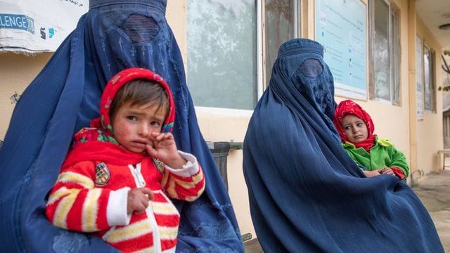 Zwei afghanische Frauen warten mit ihren Kindern vor einer Klinik für Ernährungsfragen. Zwei afghanische Frauen warten mit ihren Kindern vor einer Klinik für Ernährungsfragen.