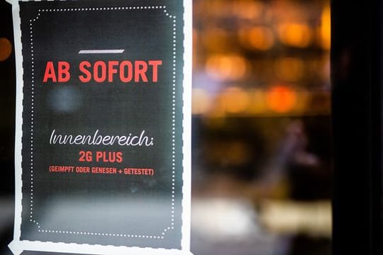 Ein Plakat weist Gäste am Eingang eines Restaurants in Stuttgart auf die neue 2G Plus Regel hin.