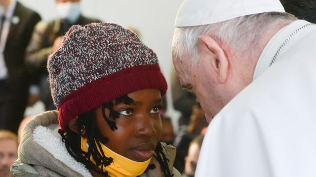 Papst Franziskus spricht während seines Besuchs im Migrantenlager Camp Kara Tepe mit einem Mädchen.