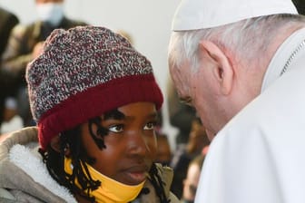 Papst Franziskus spricht während seines Besuchs im Migrantenlager Camp Kara Tepe mit einem Mädchen.