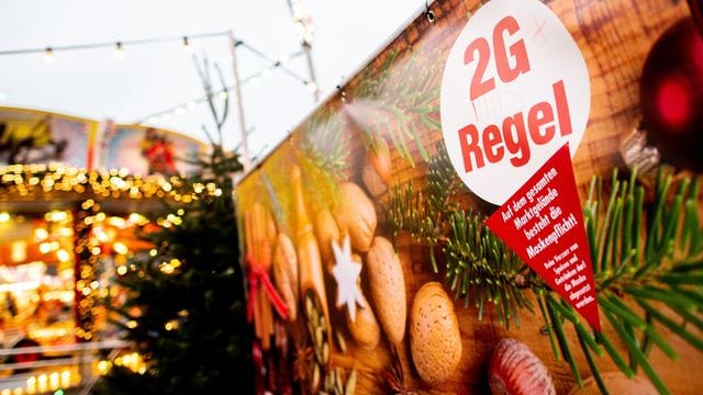 Ein Schild mit der Aufschrift "2G Regel" am Eingang eines Weihnachtsmarkts. Ein Schild mit der Aufschrift "2G Regel" am Eingang eines Weihnachtsmarkts.