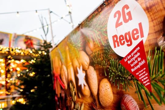 Ein Schild mit der Aufschrift "2G Regel" am Eingang eines Weihnachtsmarkts.