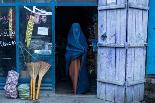 Eine afghanische Frau, die eine Burka trägt, verlässt einen kleinen Laden in Kabul (Archivbild).