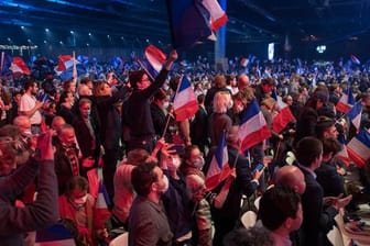 Anhänger des rechtsextremen französischen Präsidentschaftskandidaten Éric Zemmour schwenken Plakate und französische Flaggen.