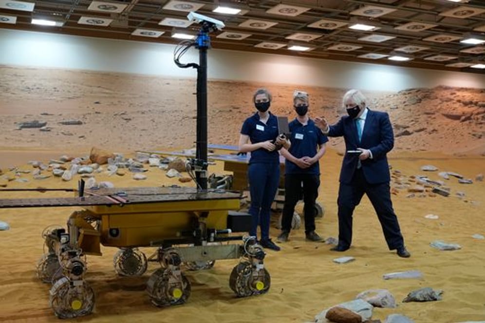 Der britische Premier Boris Johnson (r) mit einer Steuerkonsole eines Marsover-Prototypen bei einem Besuch bei Airbus (Archivbild).