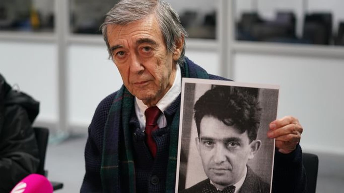 Der KZ-Überlebende und Zeuge Josef Salomonovic hält nach dem Prozess ein Foto seines Vaters Erich im Gerichtssaal hoch.