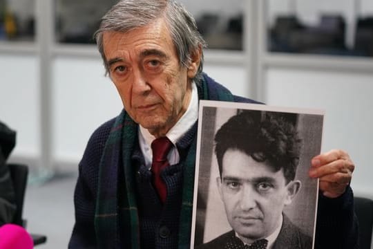 Der KZ-Überlebende und Zeuge Josef Salomonovic hält nach dem Prozess ein Foto seines Vaters Erich im Gerichtssaal hoch.