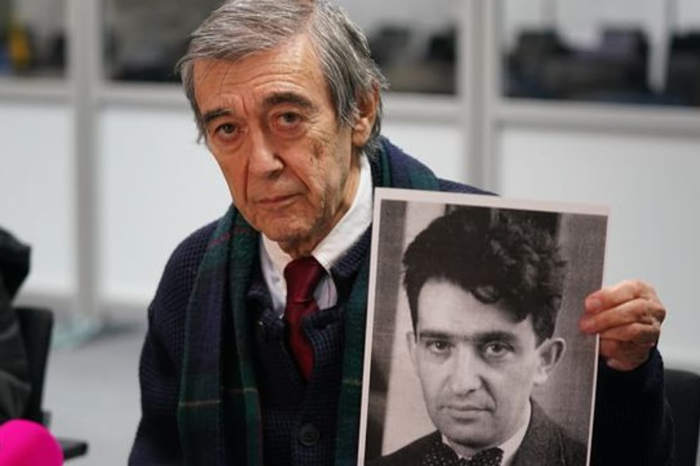 Der KZ-Überlebende und Zeuge Josef Salomonovic hält nach dem Prozess ein Foto seines Vaters Erich im Gerichtssaal hoch.